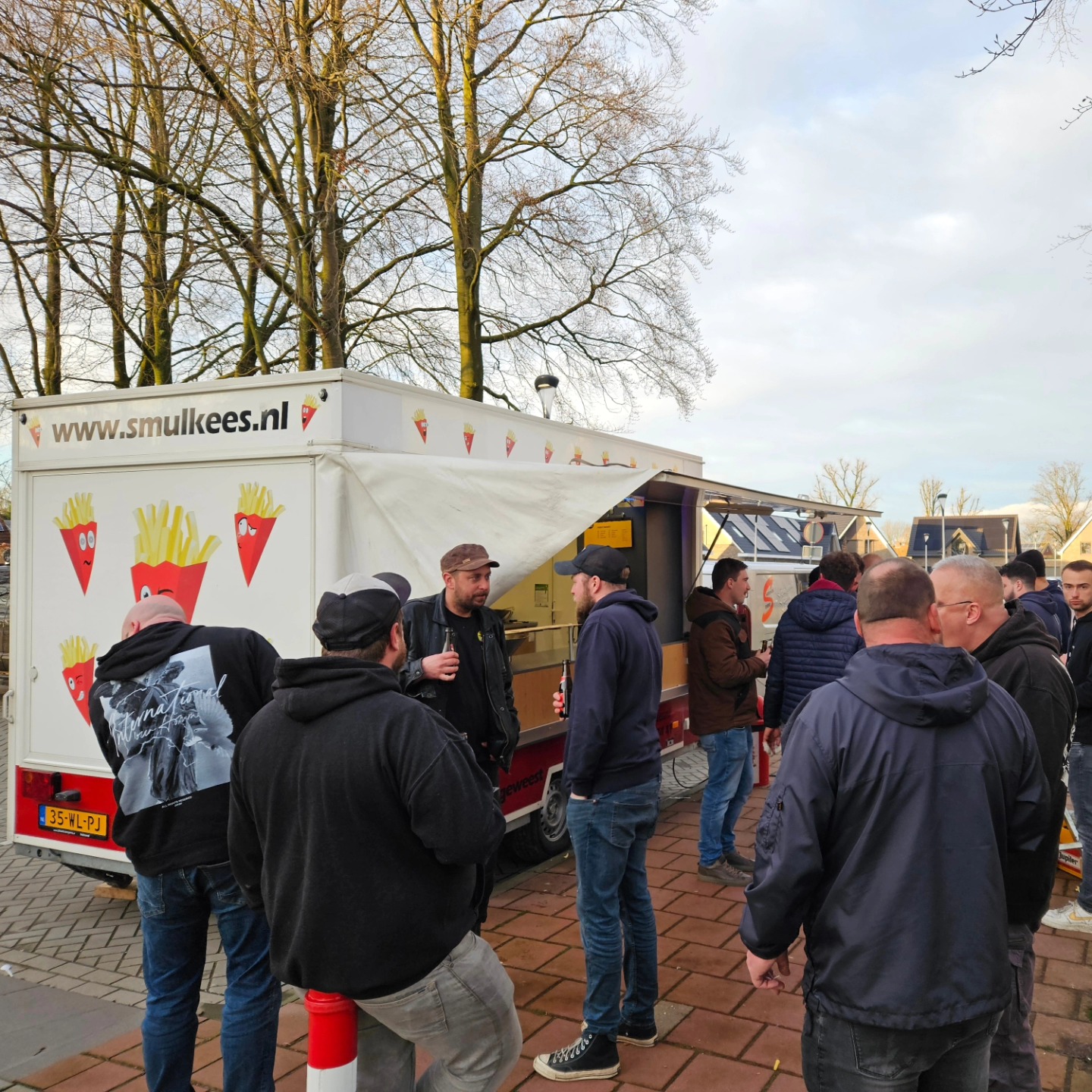 Frietkar huren kerstfeest — Smulkees frietwagen op een sfeervolle winteravond met kerstverlichting